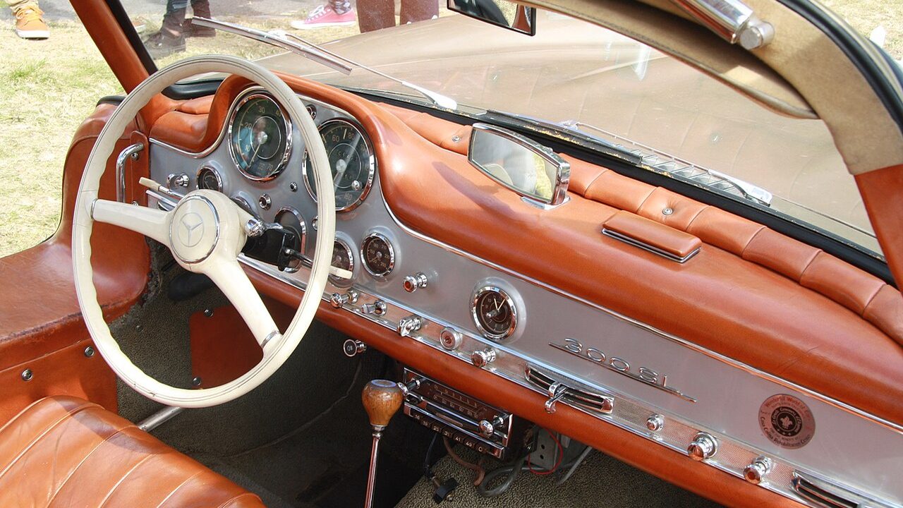 300 SL Gullwing dashboard: big speedometer and tachometer ahead of the thin-rimmed wheel, minor gauges and switches across the body-color fascia