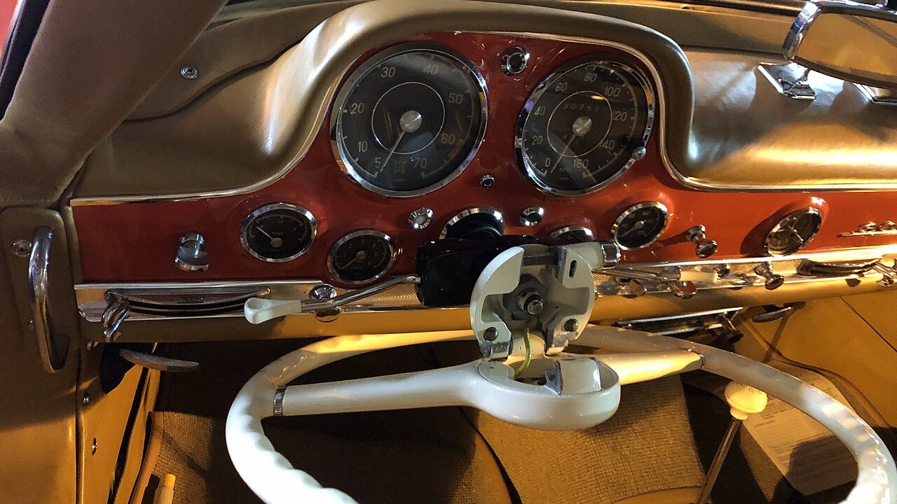 The steering wheel tilts forward on a hinge so the driver can climb over the wide sill and in